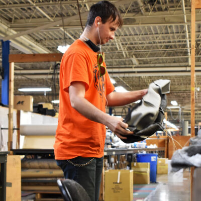 A young man turns an upholstery cover right side out