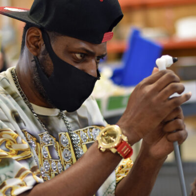 PDG-Damian A young Black man wearing a face mask focuses on a task
