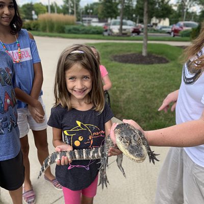 girl with gator A young girl holds a baby alligator
