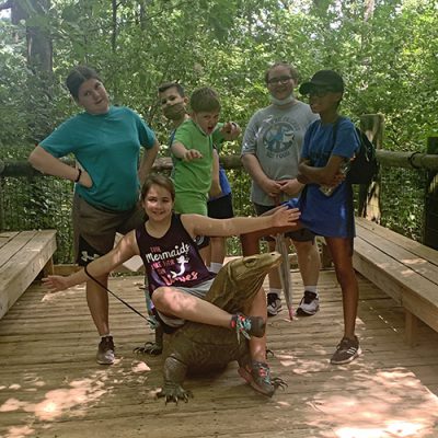 Group of children posing with kimodo dragon statue