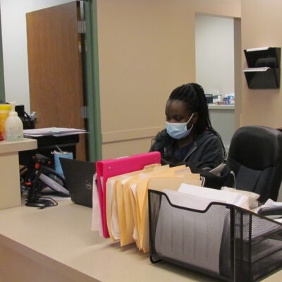 A nurse sits at the front desk.