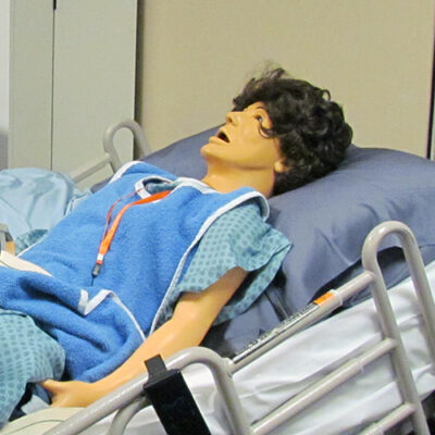 A manikin lies in a hospital bed